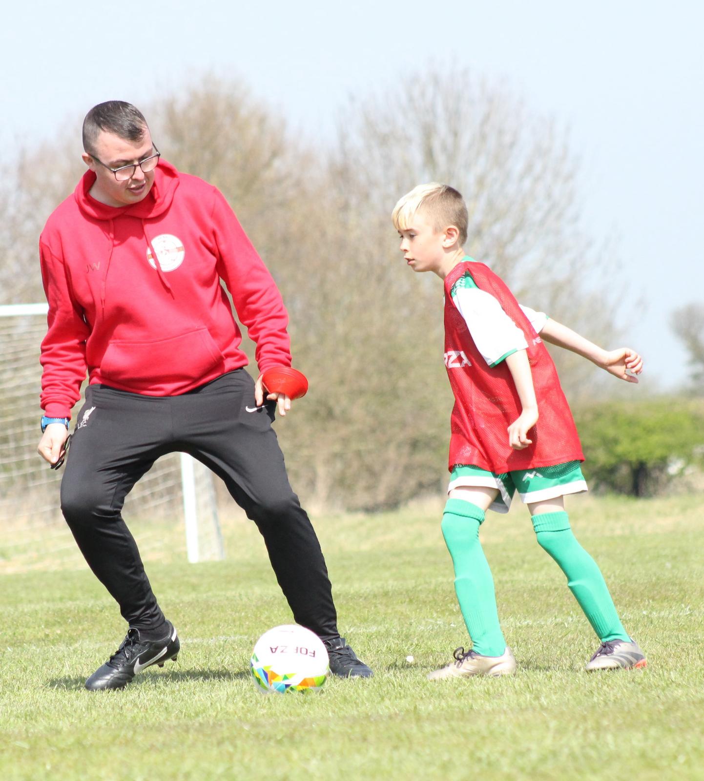 Coach Jack guiding a young player during football training in Skegness