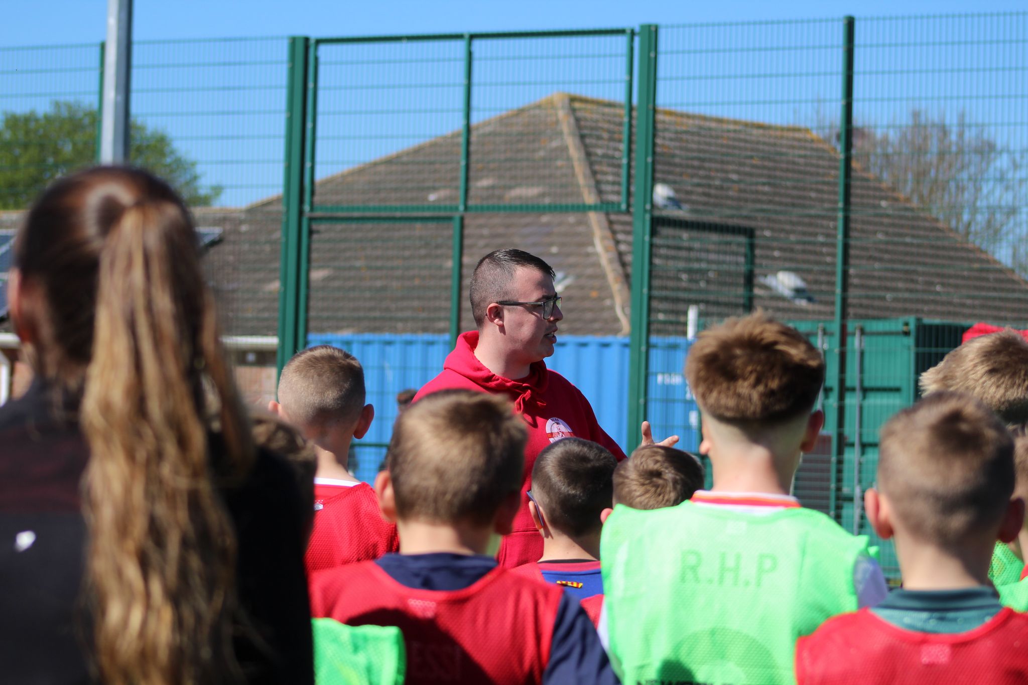 Coach Jack giving football instructions to a group of children at JCSS in Skegness