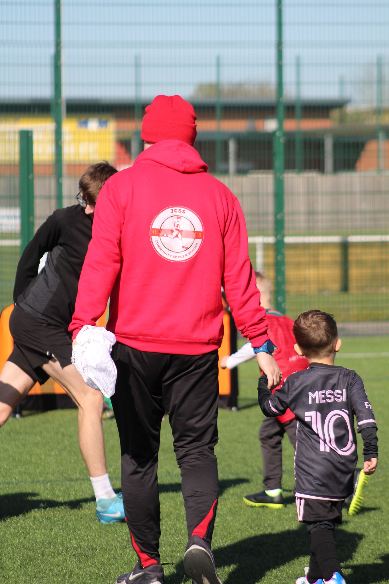 Coach Jack holding a young player's hand during football training at JCSS in Skegness