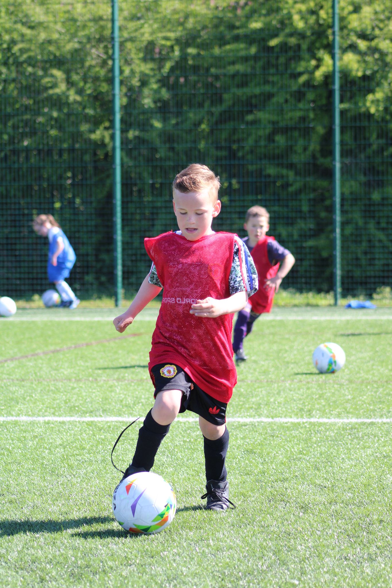 young boy in a football holiday camp dribbling on through to goal