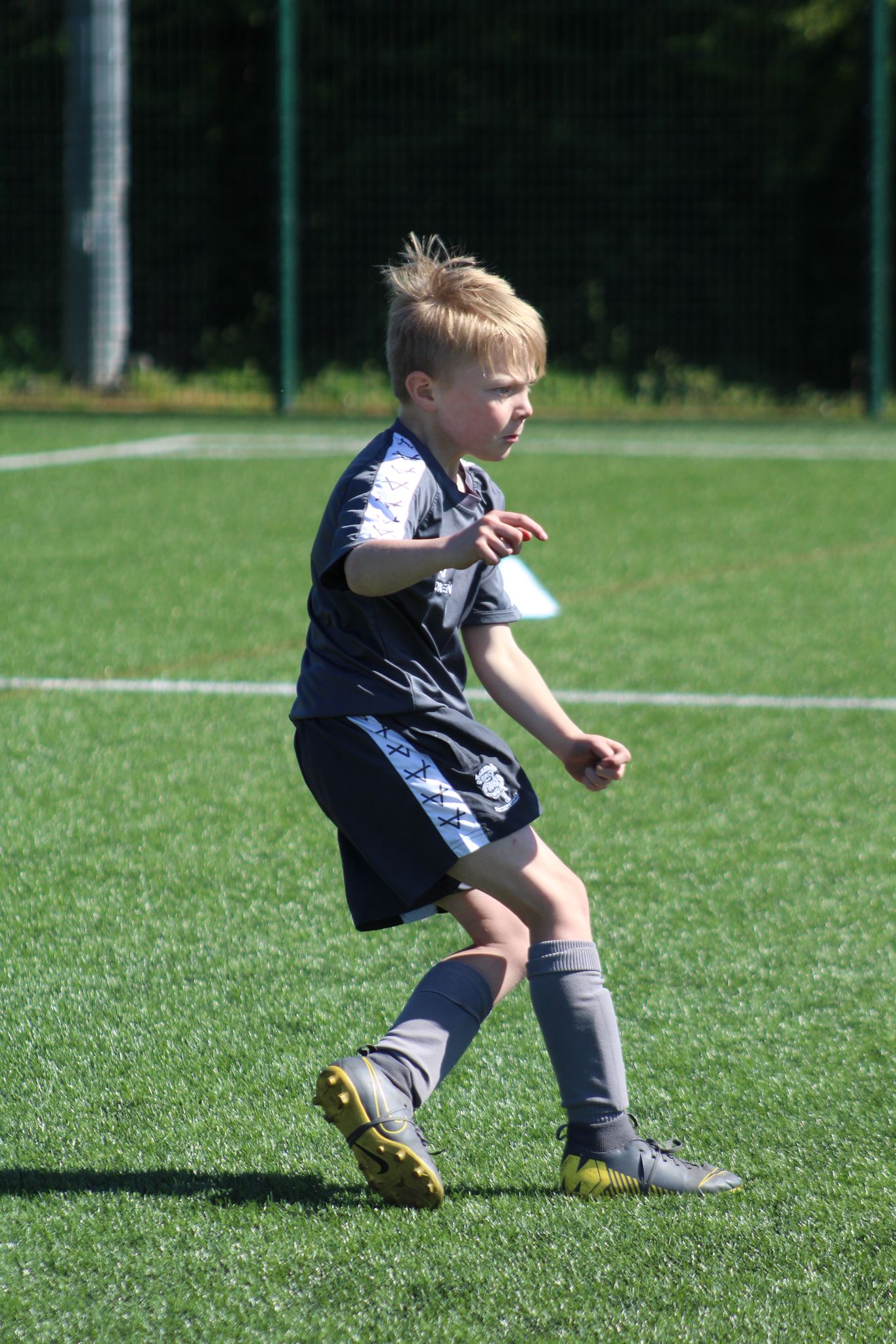 Young boy running with a football during a JCSS coaching session in Skegness