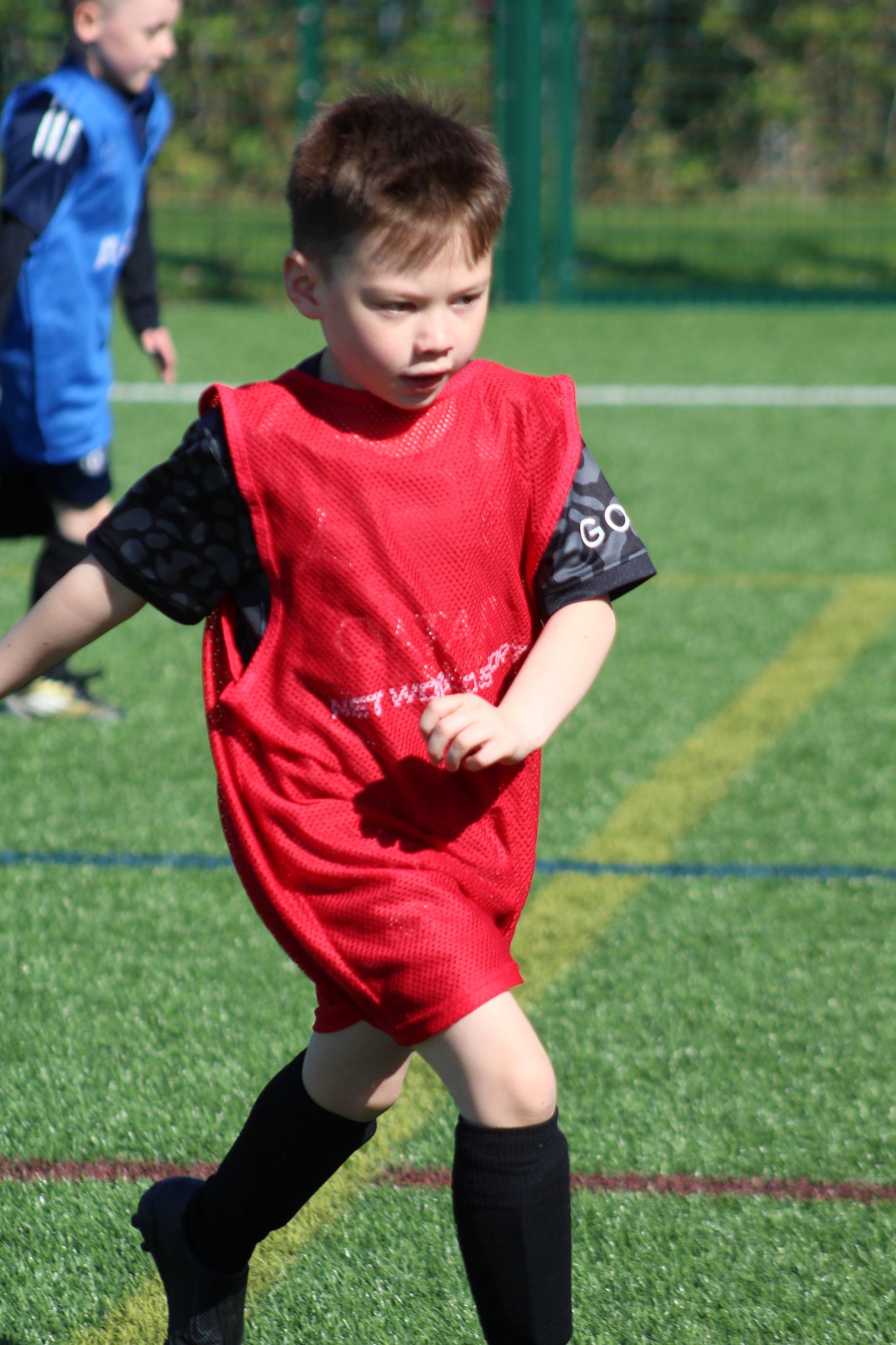Young child running with a football during a JCSS Playmakers session in Skegness