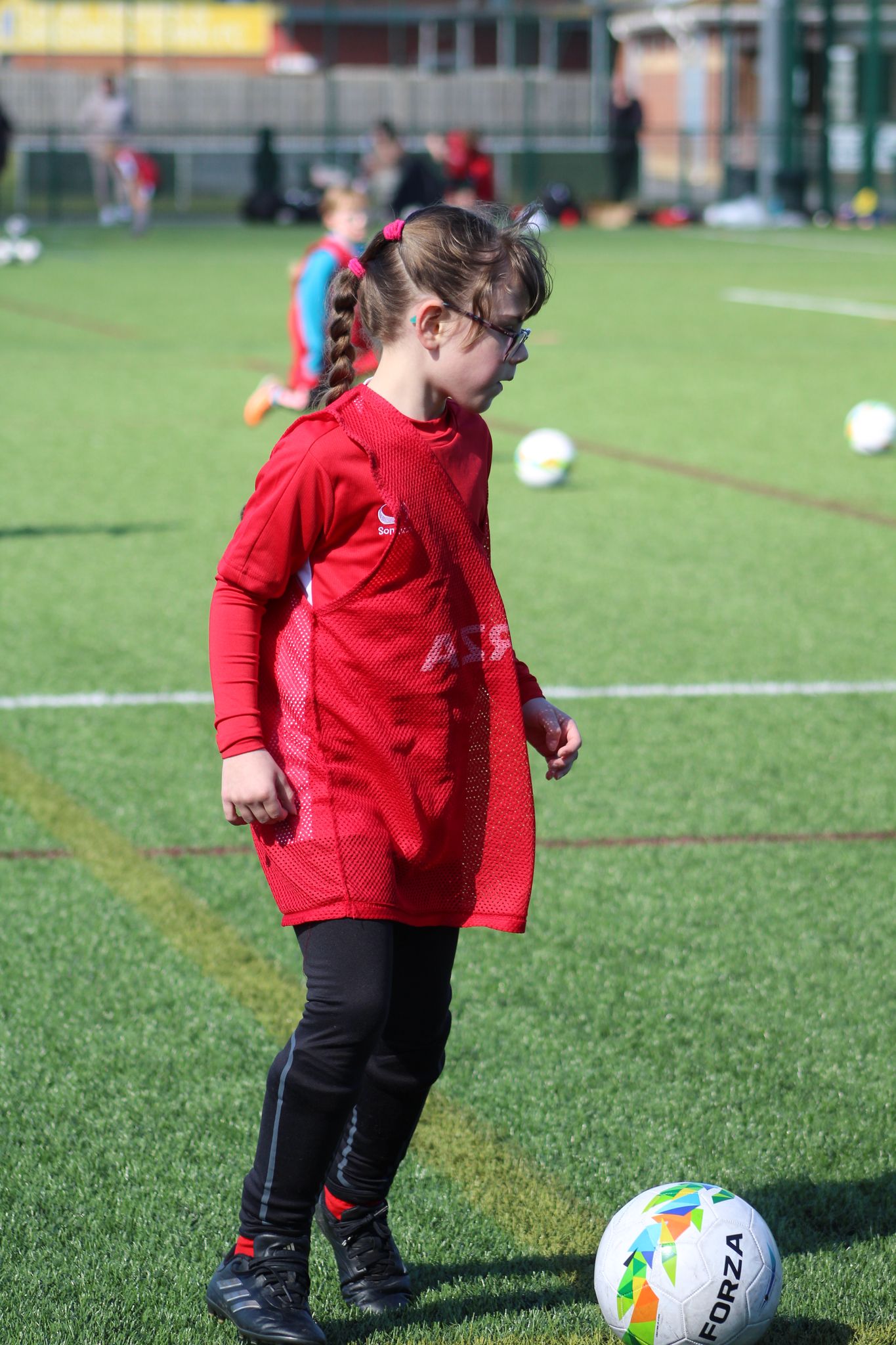 Young girl dribbling a football during JCSS coaching session in Skegness
