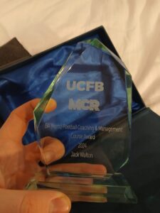 Jack holding his UCFB Football Coaching and Management award