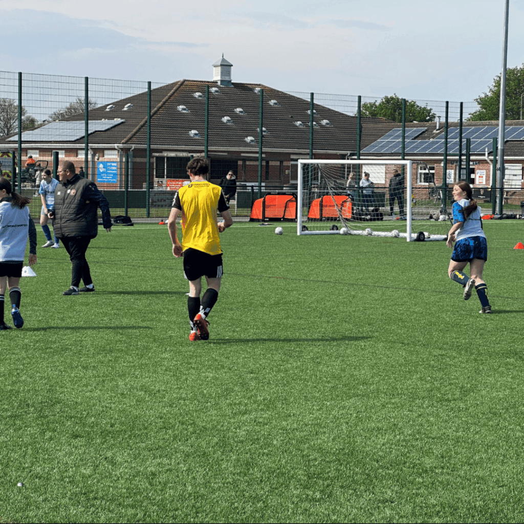 children running whilst playoing a football match at the jcss development+ soccer school in skegness