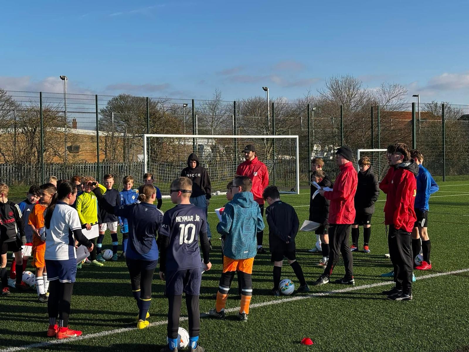 Group of children and JCSS coaches enjoying a football session at a Skegness summer camp