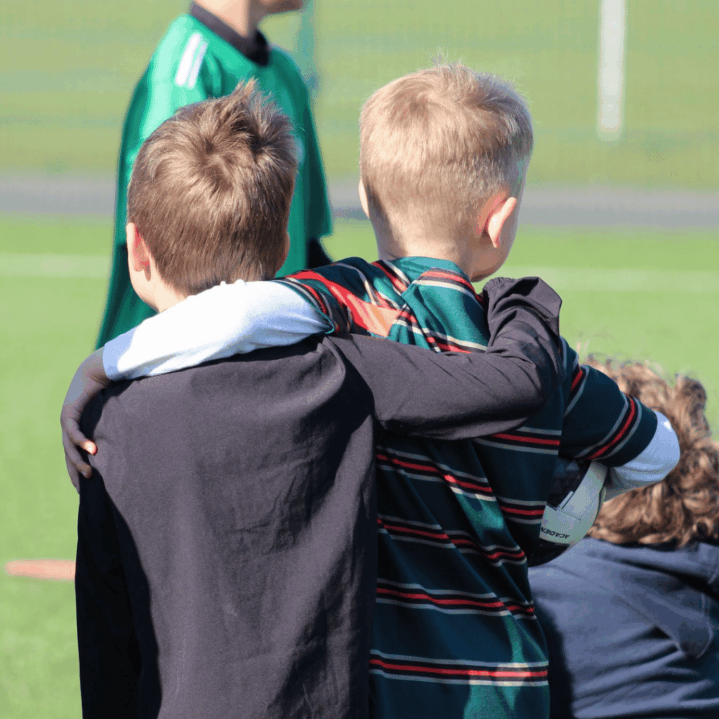 children with their arms around eachother talking at JCSS playmakers soccer school in skegness