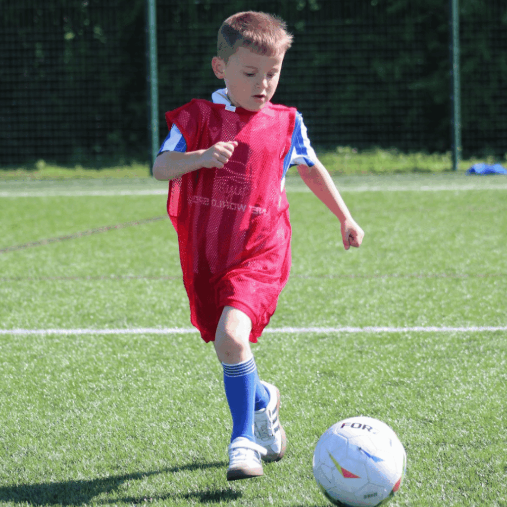 young child dribbling a football at JCSS playmakers holiday camp in Skegness