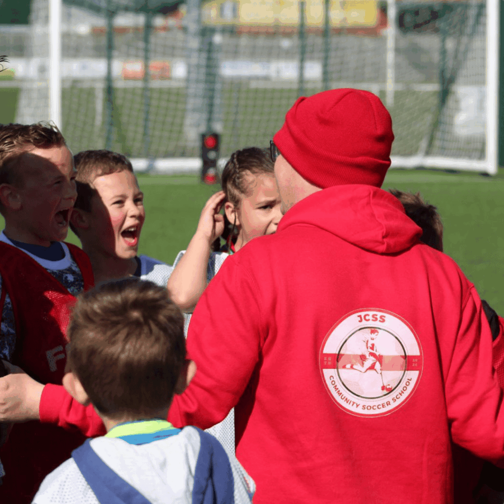 main coach jack in a huddle with a group of players giving instructions
