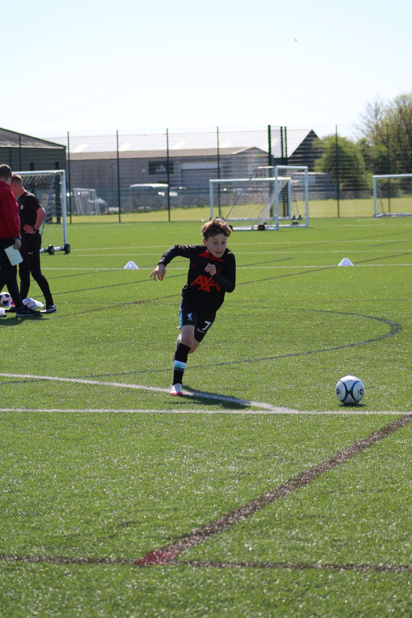 young boy in playamkers holiday camp taking a freekick