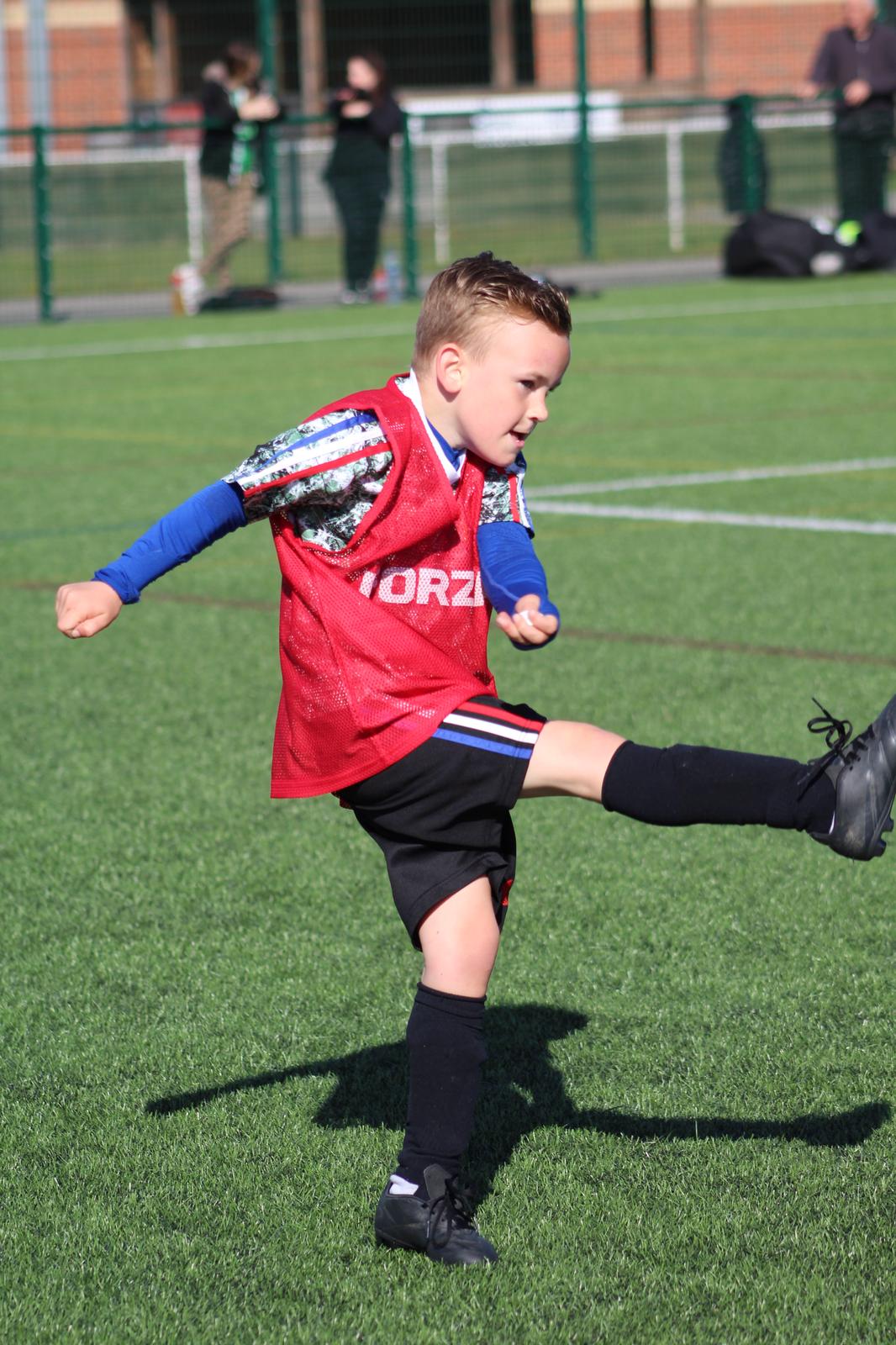 young boy in playmakers holiday camp taking a freekick