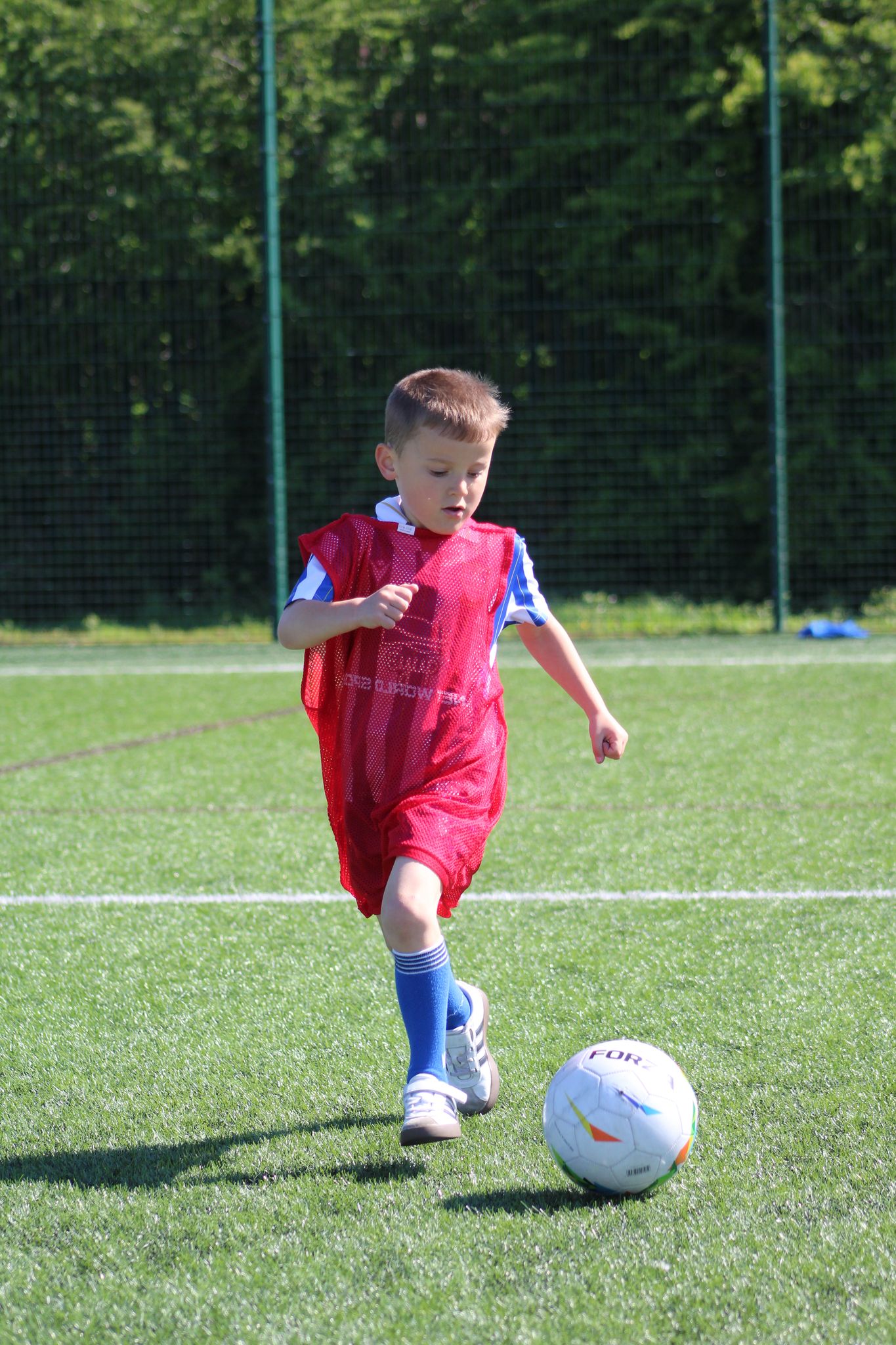 young boy in a playmakers session with the football at his feet