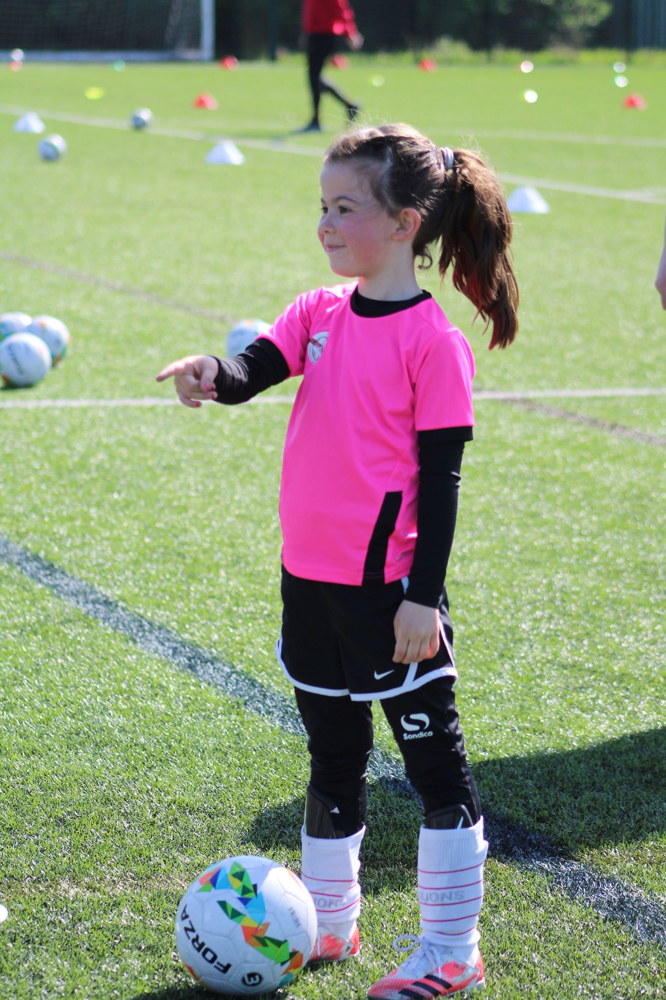 young girl in the football holiday with the ball at her feet