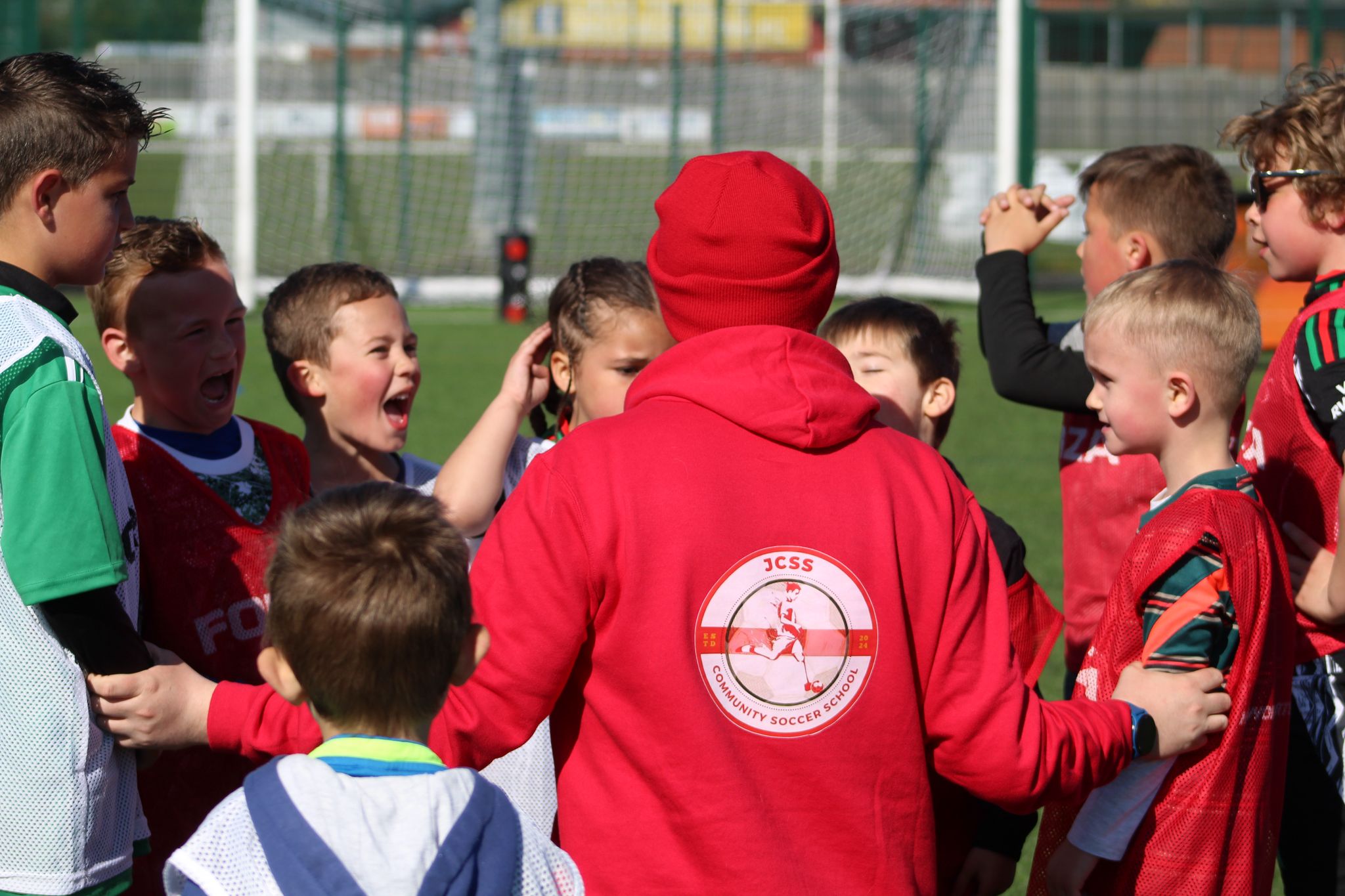 Jack giving football coaching instructions to young players at JCSS in Skegness, back view